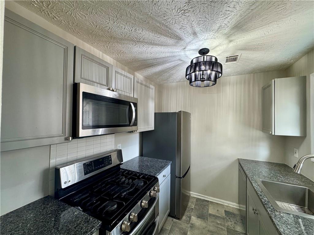 4922 Windsor Downs Lane Decatur, GA 30035 - Photo 9 of 23 a kitchen with stainless steel appliances granite countertop a sink stove and microwave