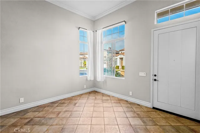 a view of an empty room with window and cabinet area