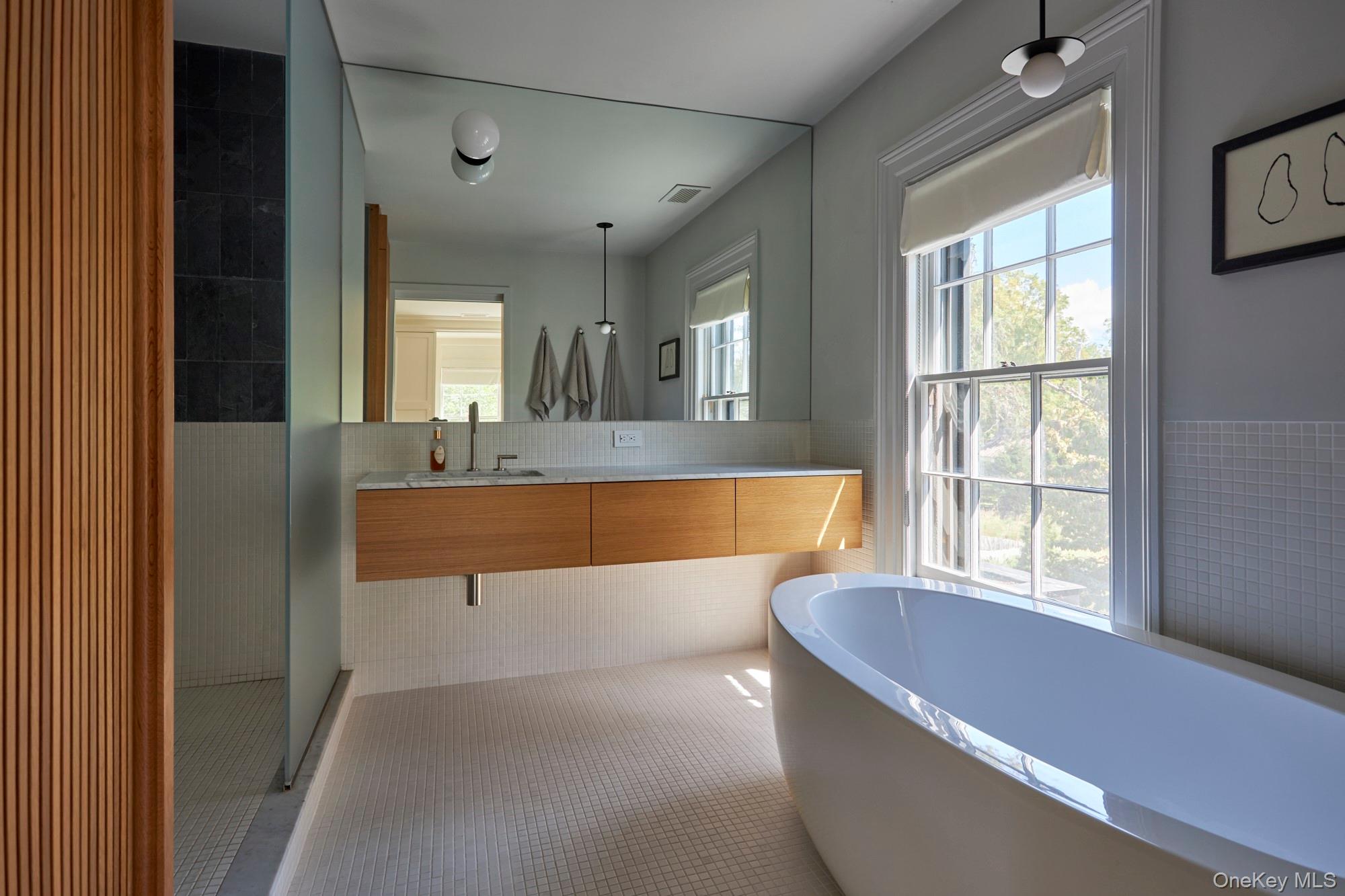 44 Main Street Germantown, NY 12526 - Photo 30 of 34 Bathroom featuring tile walls, a freestanding bath, a wainscoted wall, double vanity, and a shower stall