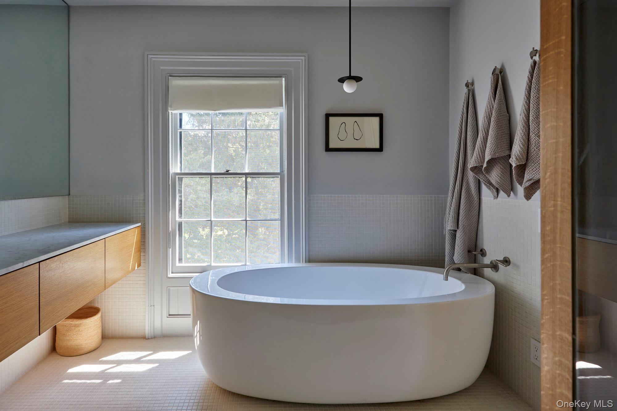 44 Main Street Germantown, NY 12526 - Photo 32 of 34 Bathroom featuring tile walls, a soaking tub, wainscoting, vanity, and tile patterned flooring