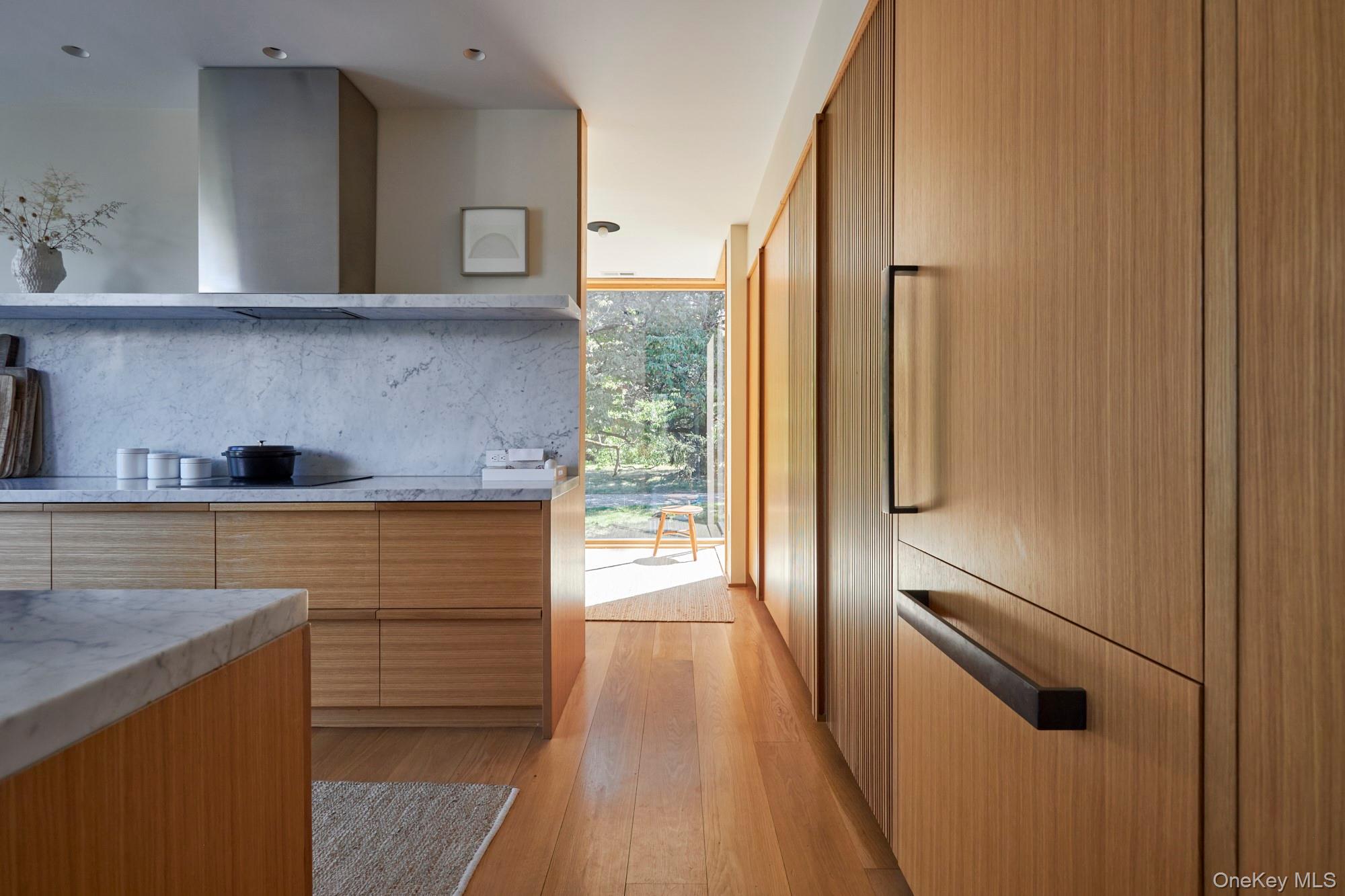 44 Main Street Germantown, NY 12526 - Photo 5 of 34 Kitchen with light wood-style flooring, wall chimney range hood, floor to ceiling windows, modern cabinets, and light stone countertops