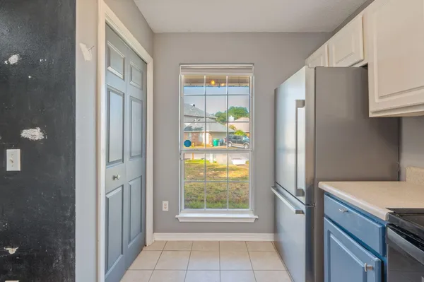 a view of a kitchen with an entryway and a refrigerator