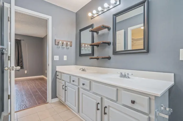 a bathroom with a double vanity sink mirror and bathtub
