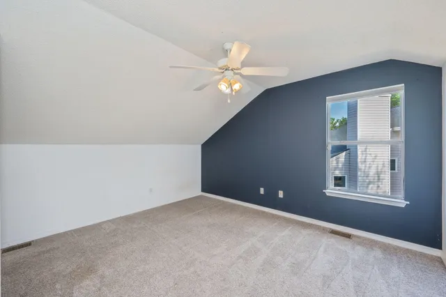 an empty room with windows and fan