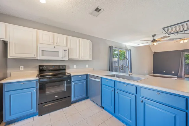 a kitchen with wooden cabinets and white appliances