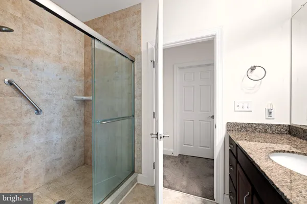 a bathroom with a granite countertop shower and a sink