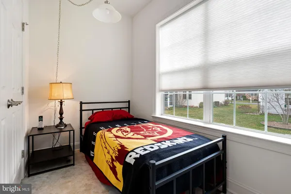 a bedroom with a bed and a large window