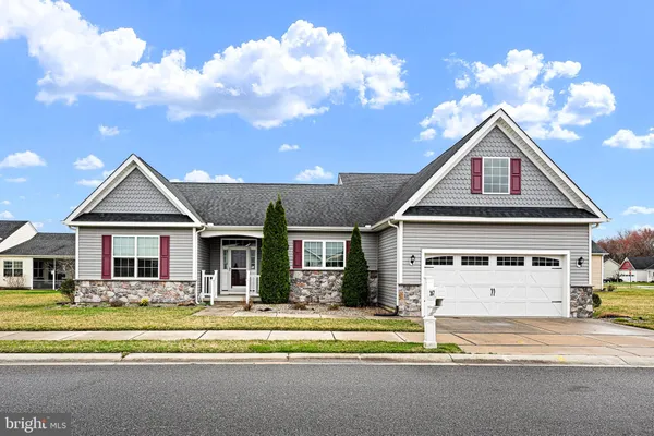 a front view of a house with a yard outdoor seating and garage