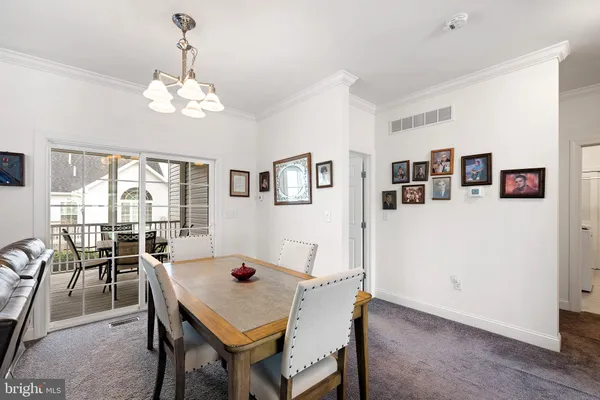 a view of a dining room with furniture a chandelier and wooden floor