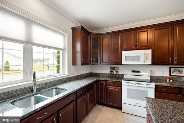 a kitchen with stainless steel appliances wooden cabinets a sink and a stove