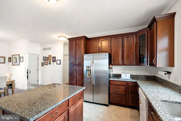 a kitchen with granite countertop a refrigerator and stove