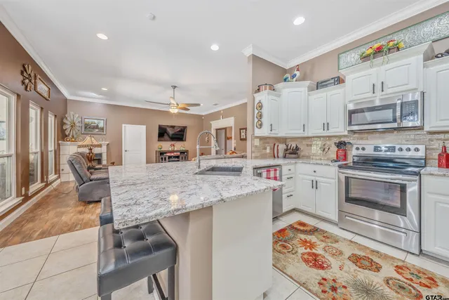 a kitchen with stainless steel appliances granite countertop a sink stove and cabinets