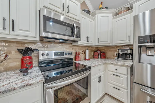 a kitchen with stainless steel appliances granite countertop a stove and a microwave