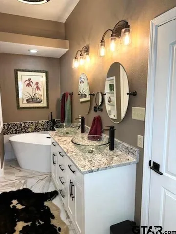 a bathroom with a granite countertop sink and a mirror