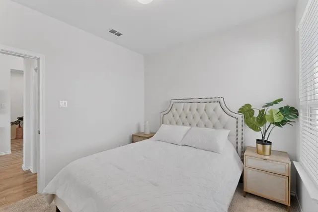 a bedroom with a bed and a potted plant
