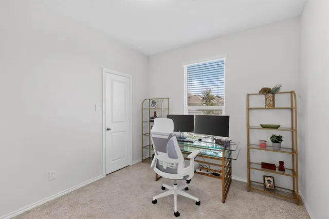a view of a workspace with furniture and a window