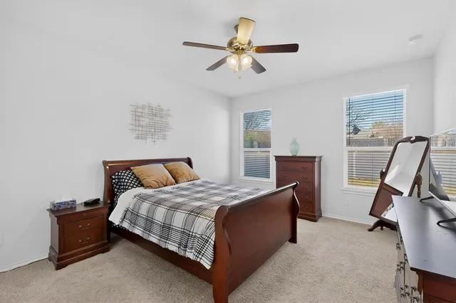 a bedroom with a bed a dresser and a window