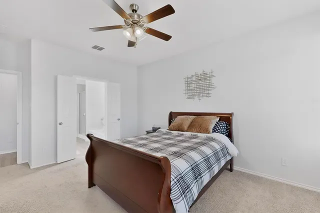 a bedroom with a bed and a ceiling fan