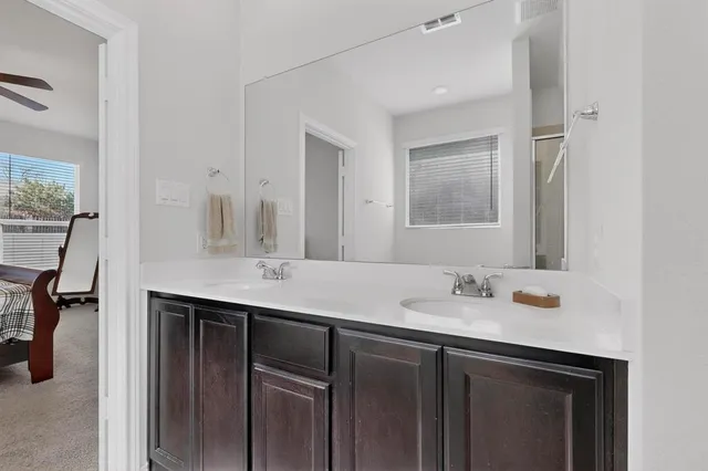 a bathroom with a sink double vanity granite and a mirror