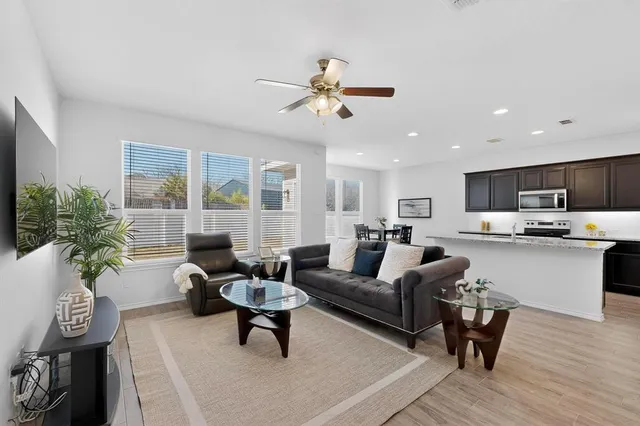 a living room with furniture and a view of kitchen
