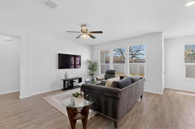 a living room with furniture a flat screen tv and a window