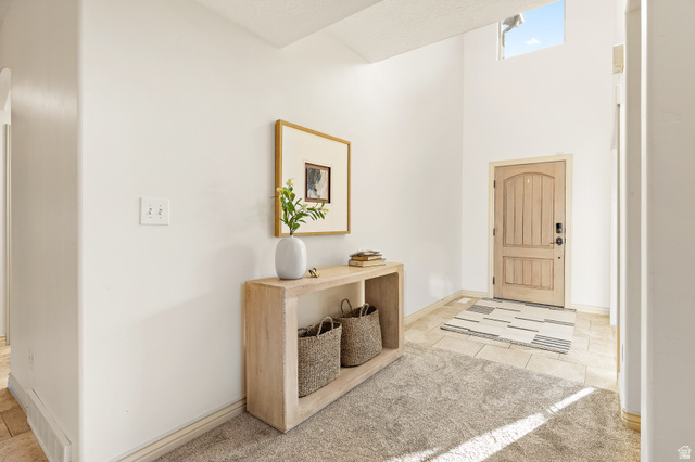 912 North Loafer Canyon Road Elk Ridge, UT 84651 - Photo 10 of 98 Vaulted ceiling entry with a wood-panel arched door, transom window, and tile flooring