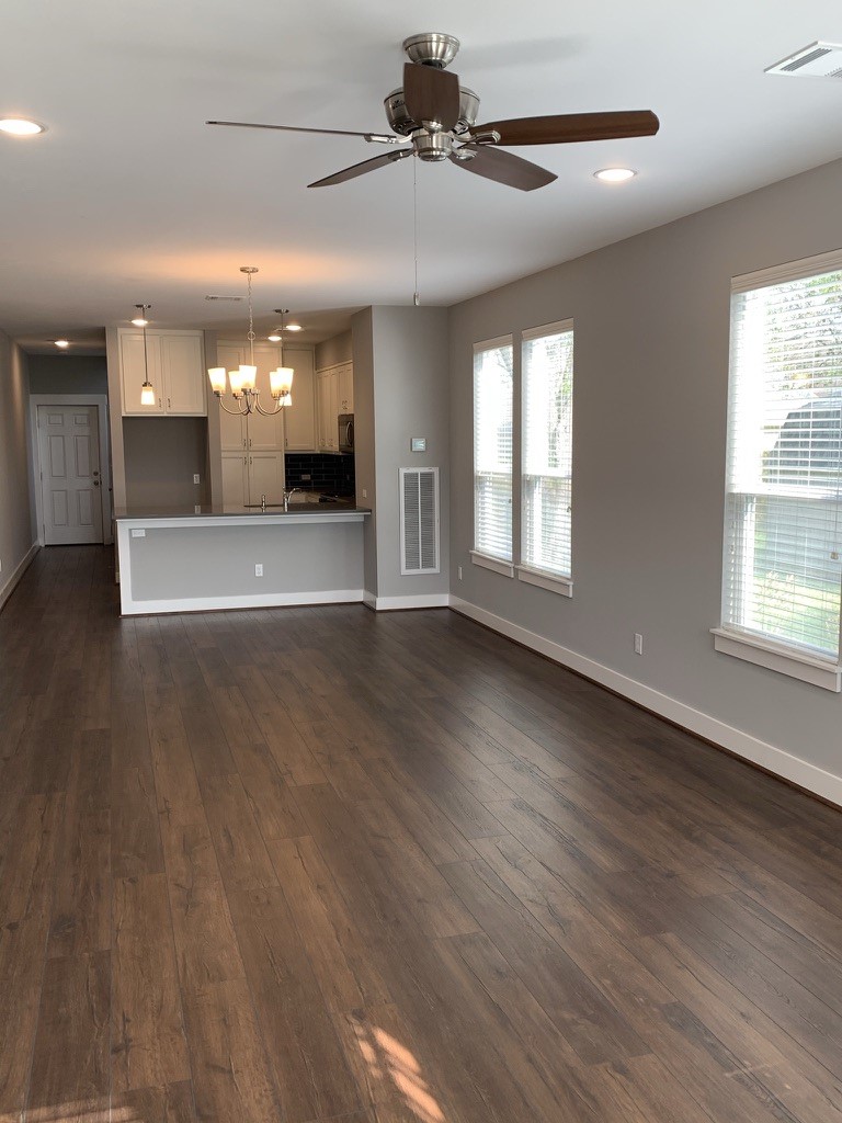 2509 South Grand Boulevard, Unit B Pearland, TX 77581 - Photo 3 of 13 an empty room with wooden floor and windows
