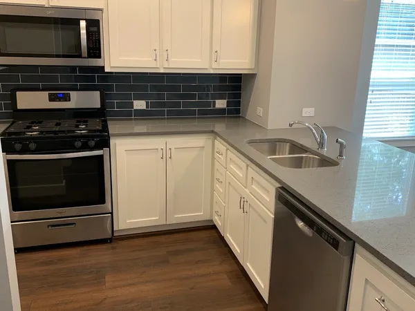 a kitchen with granite countertop a stove and a microwave