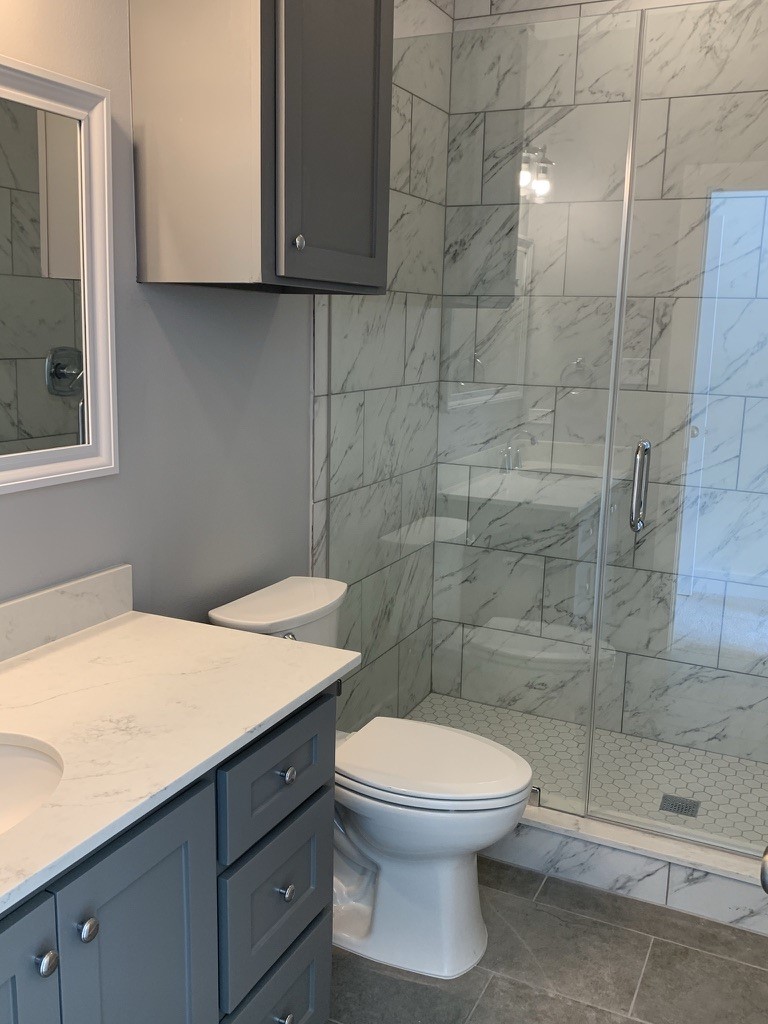 2509 South Grand Boulevard, Unit B Pearland, TX 77581 - Photo 8 of 13 a bathroom with a sink a toilet and shower