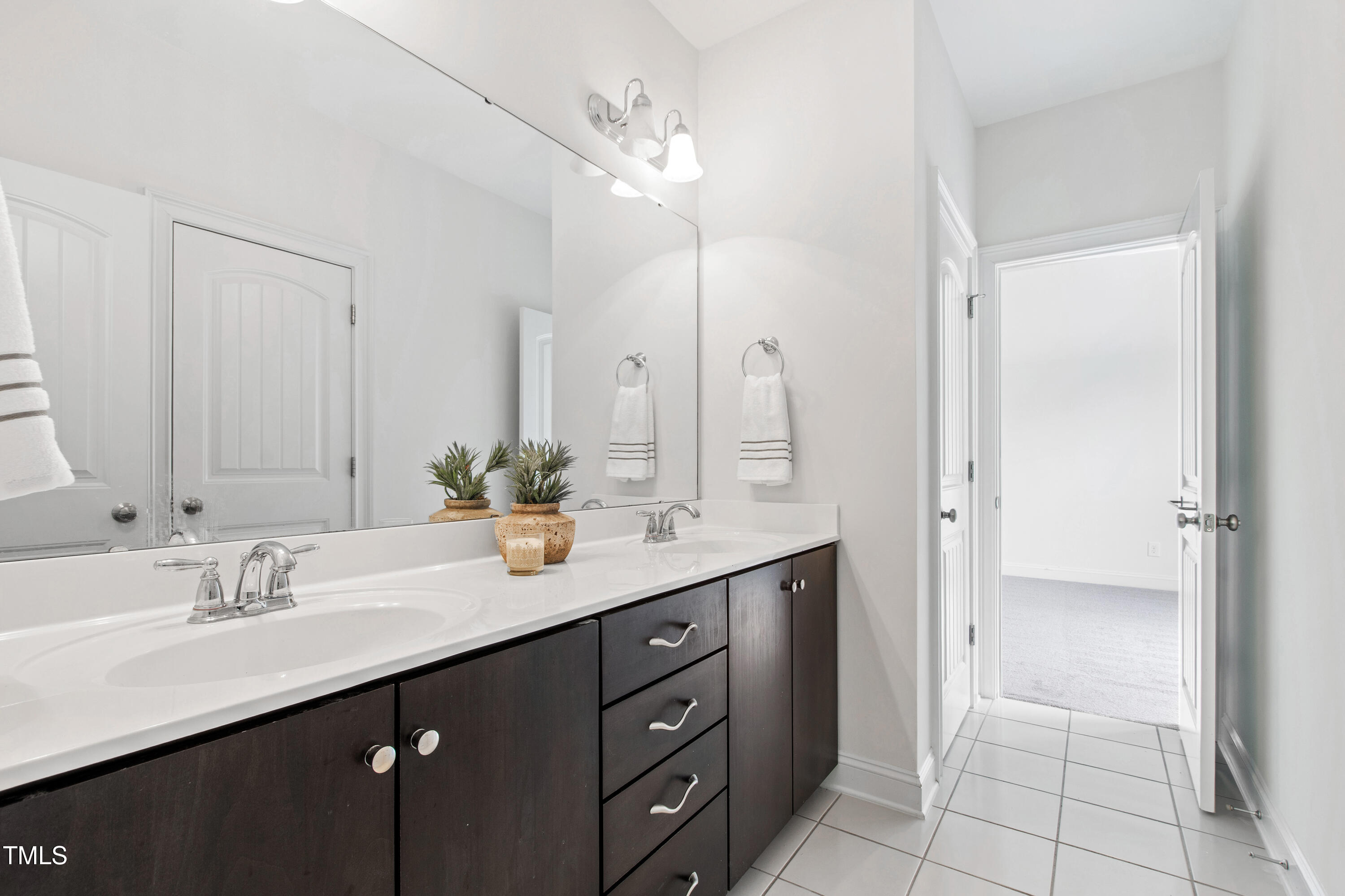 12833 Edsel Drive Raleigh, NC 27613 - Photo 54 of 72 a bathroom with a double vanity sink a mirror and a shower