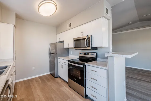 a kitchen with white cabinets stainless steel appliances and sink
