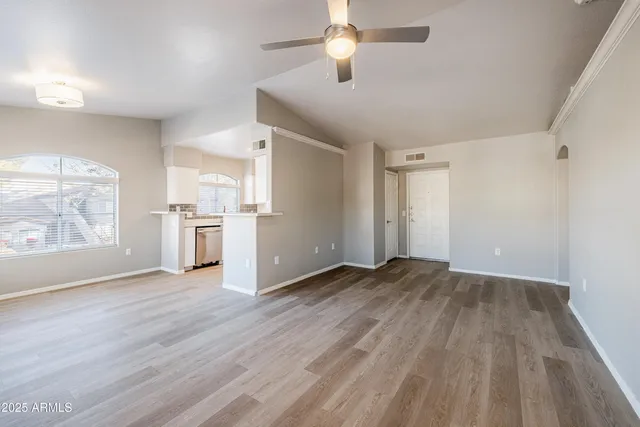 a view of empty room with wooden floor and window