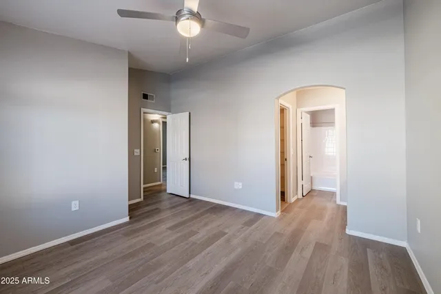 an empty room with wooden floor and mirror