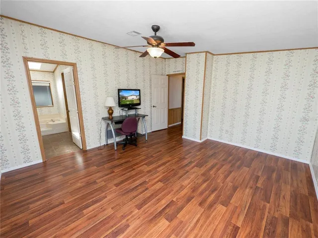a view of a livingroom with wooden floor and a ceiling fan