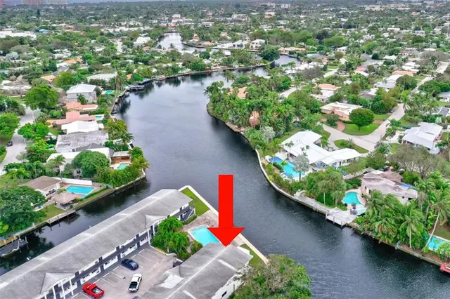 an aerial view of a house with a yard and lake view in back