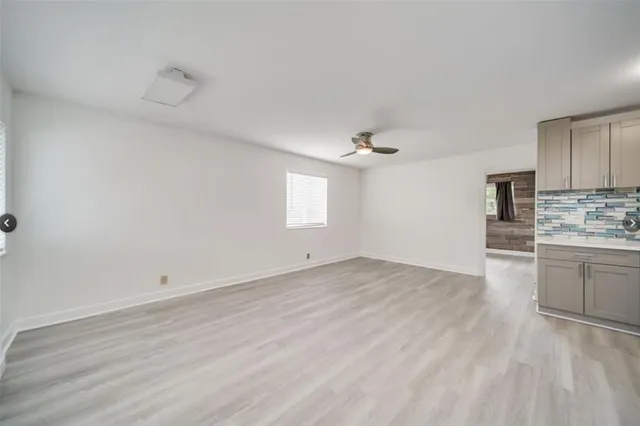 a view of a kitchen with wooden floor and cabinets