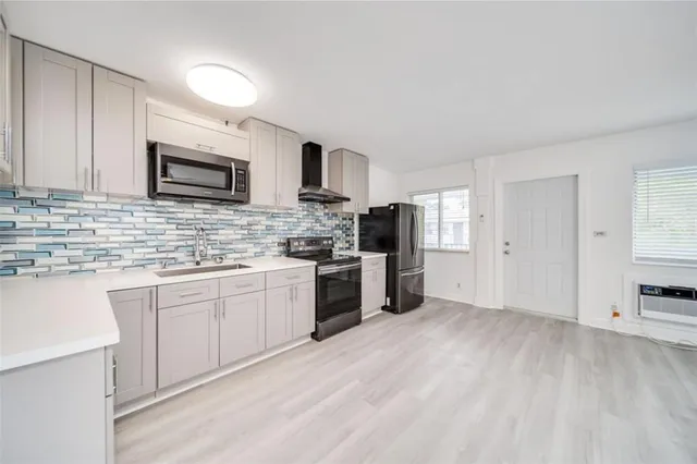 a kitchen with granite countertop a refrigerator and a stove top oven