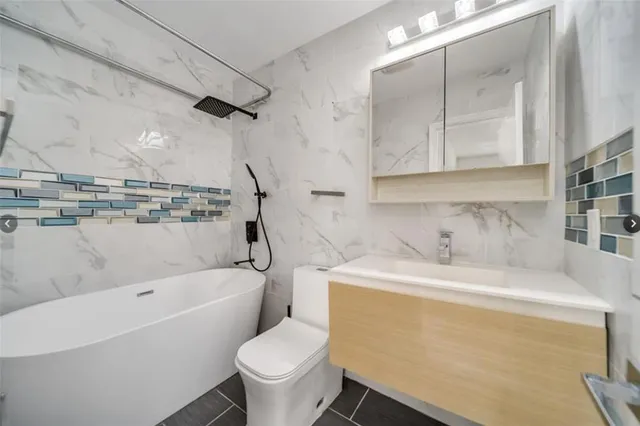 a bathroom with a sink toilet vanity and bathtub