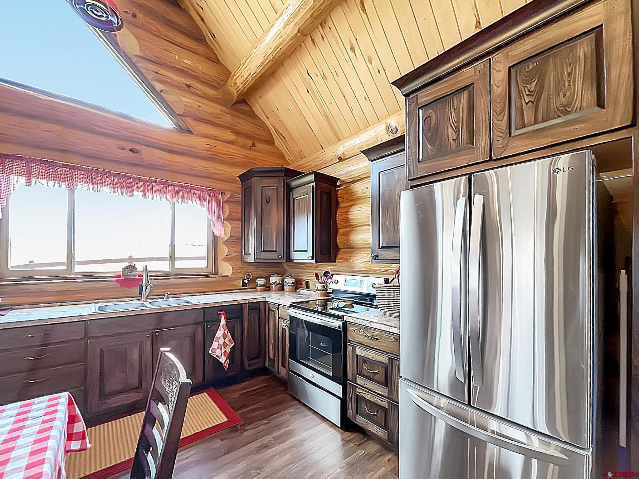 78114 Basalt Road Crawford, CO 81415 - Photo 16 of 35 a kitchen with stainless steel appliances granite countertop a refrigerator a sink dishwasher a stove and white countertops with wooden floor