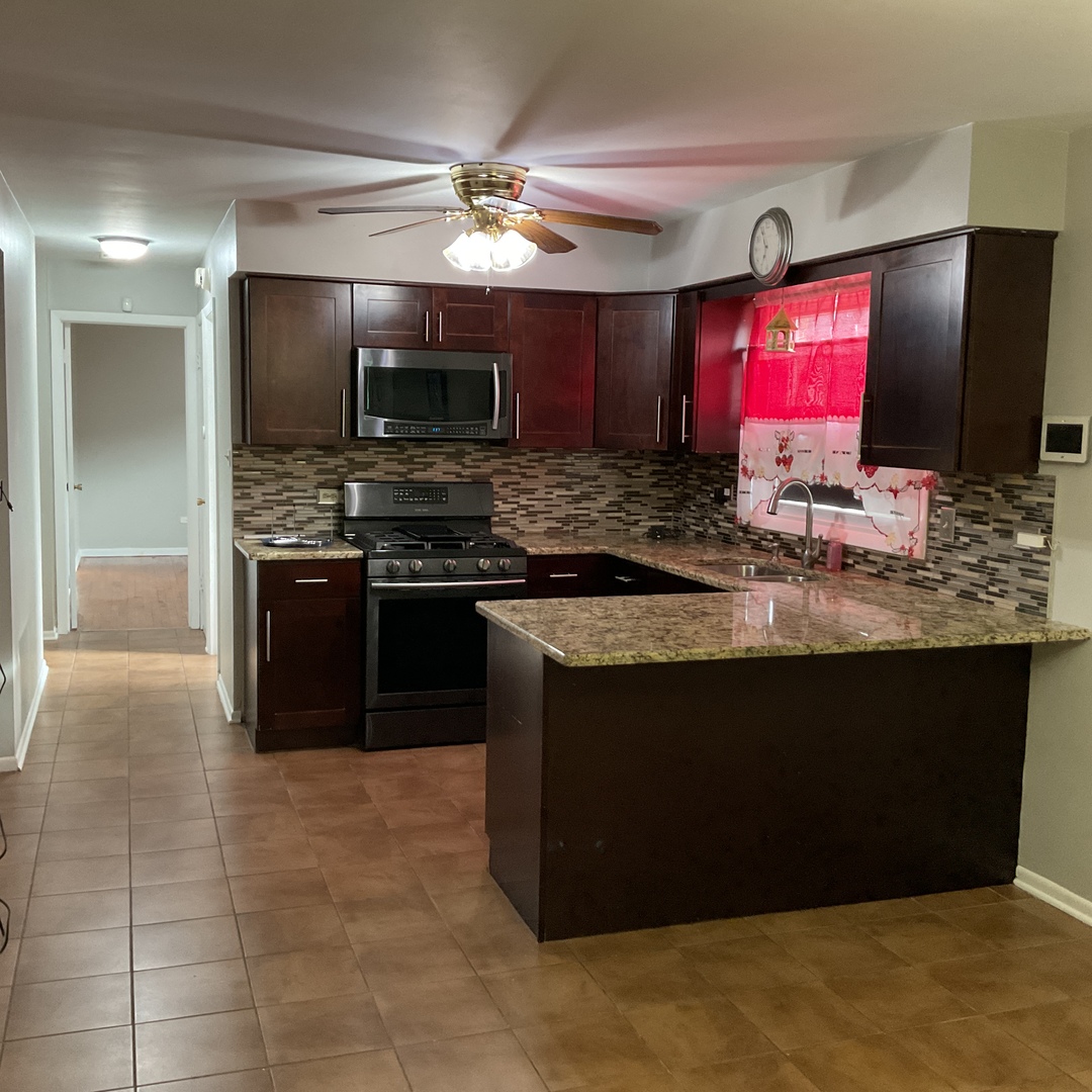 604 Exchange Avenue Calumet City, IL 60409 - Photo 12 of 39 a kitchen with stainless steel appliances granite countertop a stove top oven a sink and a microwave