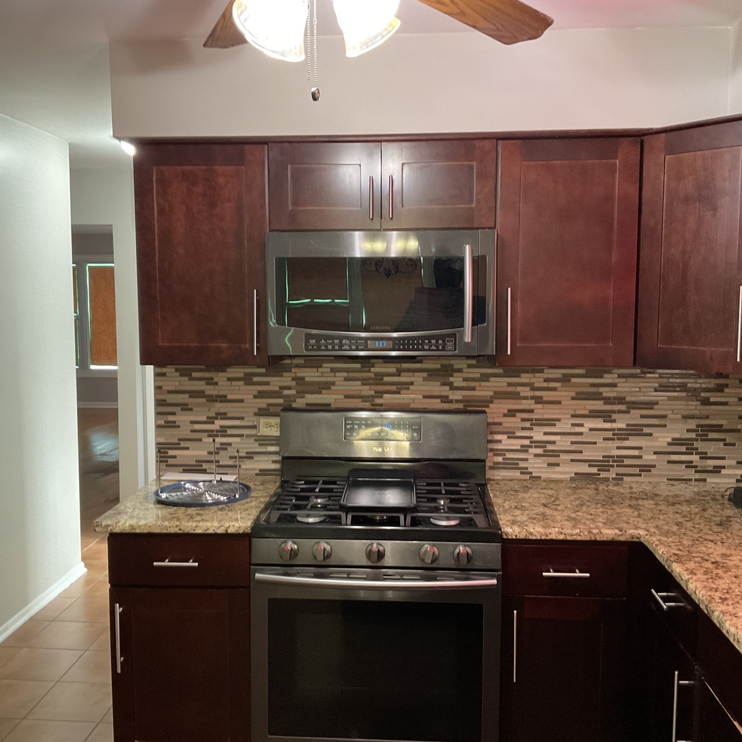 604 Exchange Avenue Calumet City, IL 60409 - Photo 10 of 39 a kitchen with stainless steel appliances wooden cabinets and a stove top oven