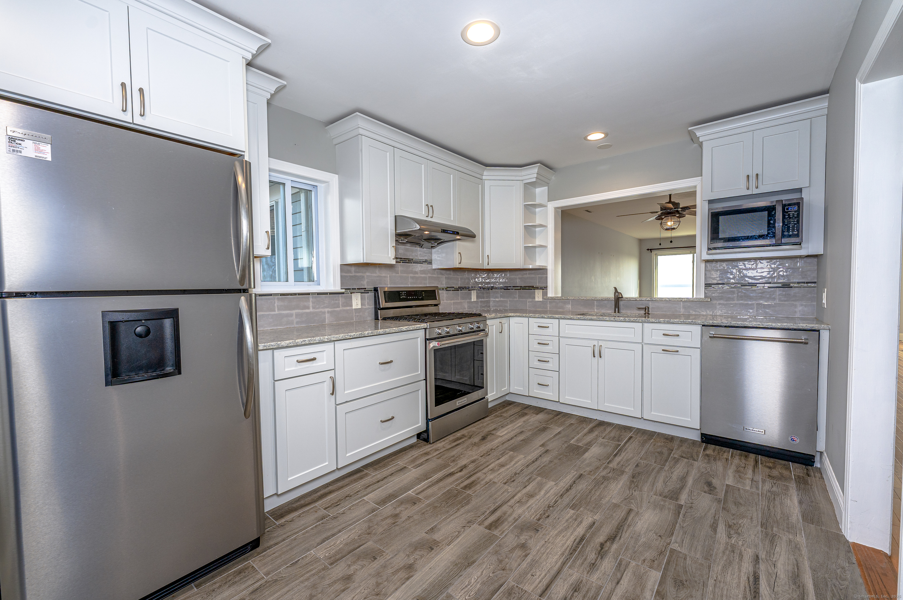 2 Mansfield Grove Road, Unit 374 East Haven, CT 06512 - Photo 11 of 30 a kitchen with white cabinets stainless steel appliances and window