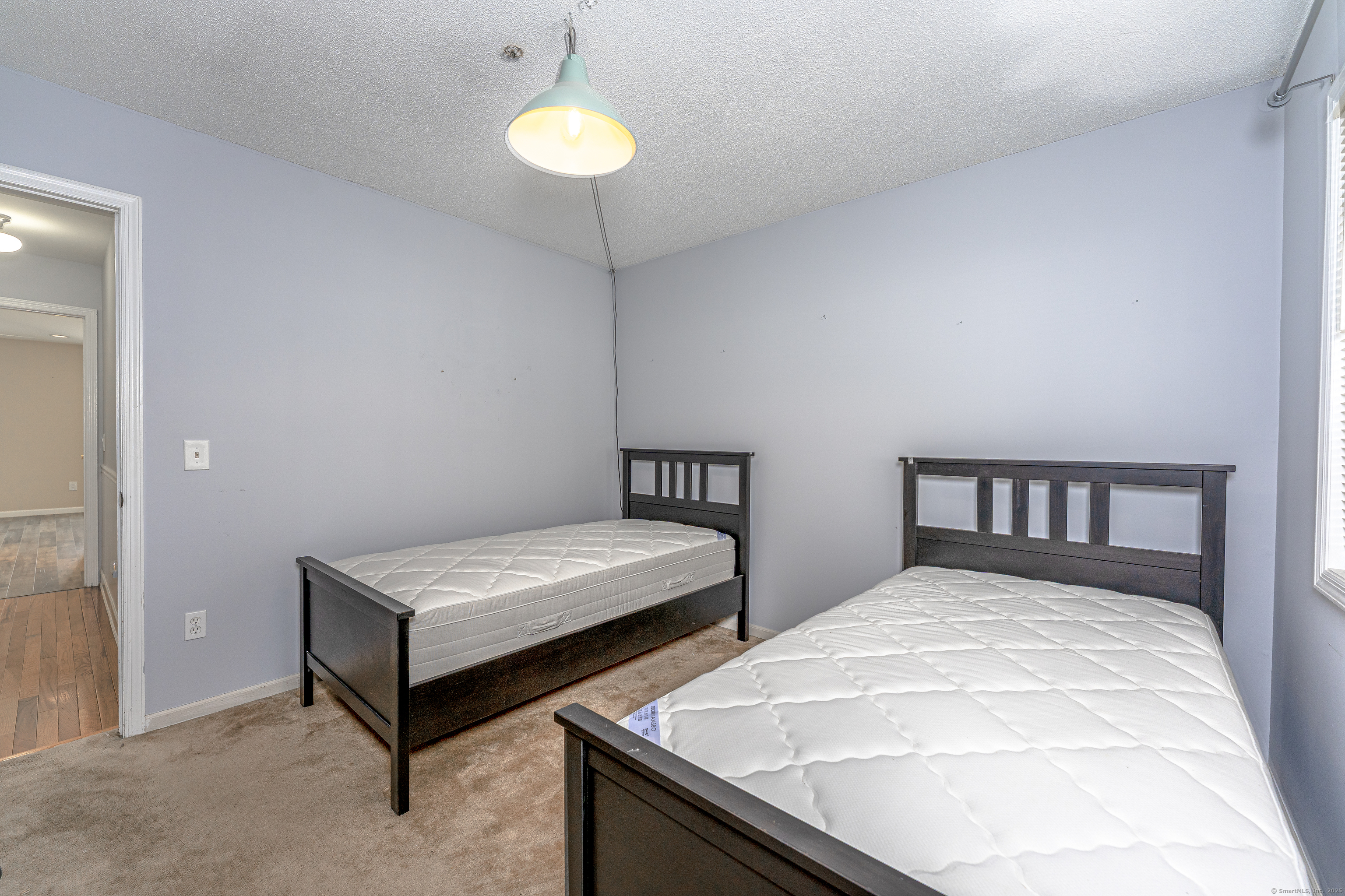 2 Mansfield Grove Road, Unit 374 East Haven, CT 06512 - Photo 14 of 30 a bedroom with two beds and a chandelier