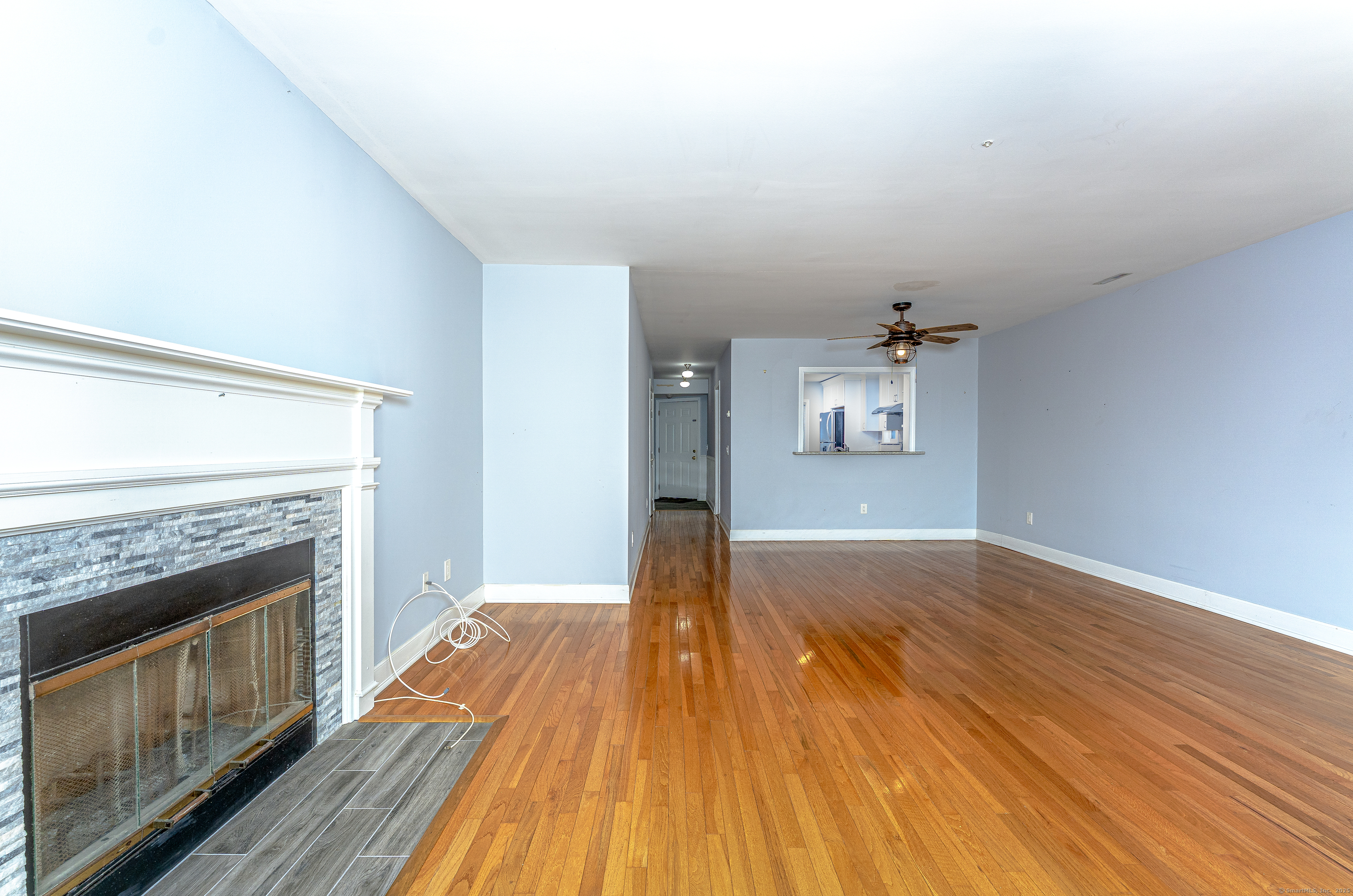 2 Mansfield Grove Road, Unit 374 East Haven, CT 06512 - Photo 7 of 30 a view of a livingroom with wooden floor and a fireplace