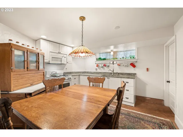 a kitchen with stainless steel appliances kitchen island granite countertop a sink a stove and a wooden floors