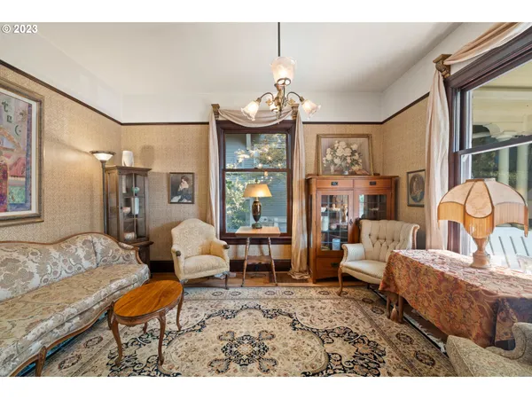 a living room with furniture a chandelier and a dining table