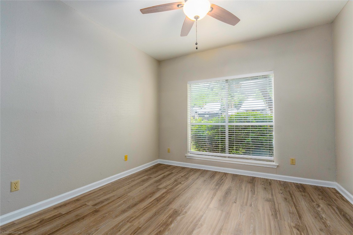 2450 Wickersham Lane, Unit 1001 Austin, TX 78741 - Photo 10 of 18 an empty room with wooden floor and windows