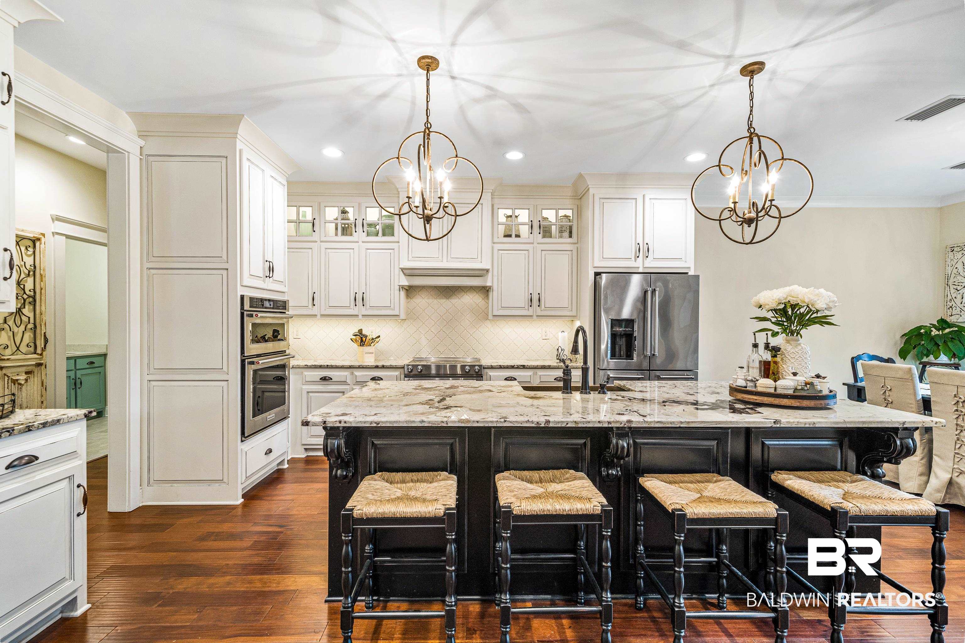 36784 Legacy Way Bay Minette, AL 36507 - Photo 11 of 57 Kitchen featuring high end appliances, stone countertops, copper sink, and a center island with two dishwashers and additional storage under the island.