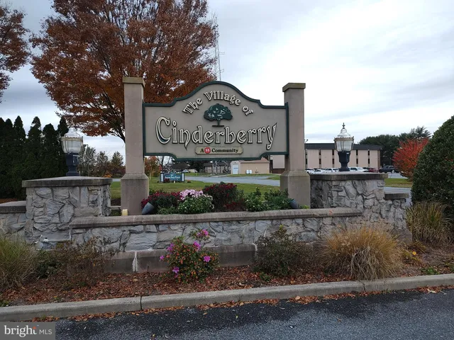 a sign board with buildings in the background