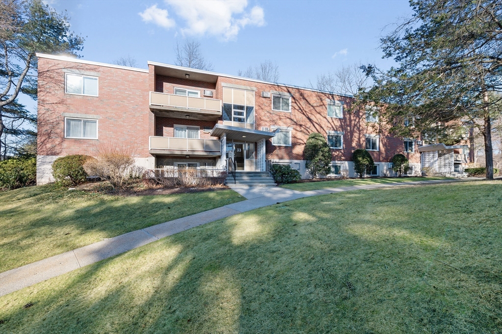 33 Jacqueline Road, Unit D Waltham, MA 02452 - Photo 1 of 26 a front view of a building with a yard